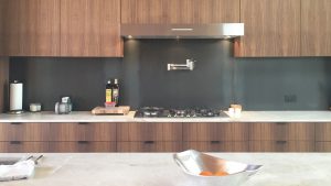 Kitchen Cabinets made with Walnut and Metal Backsplash and Stone Counter